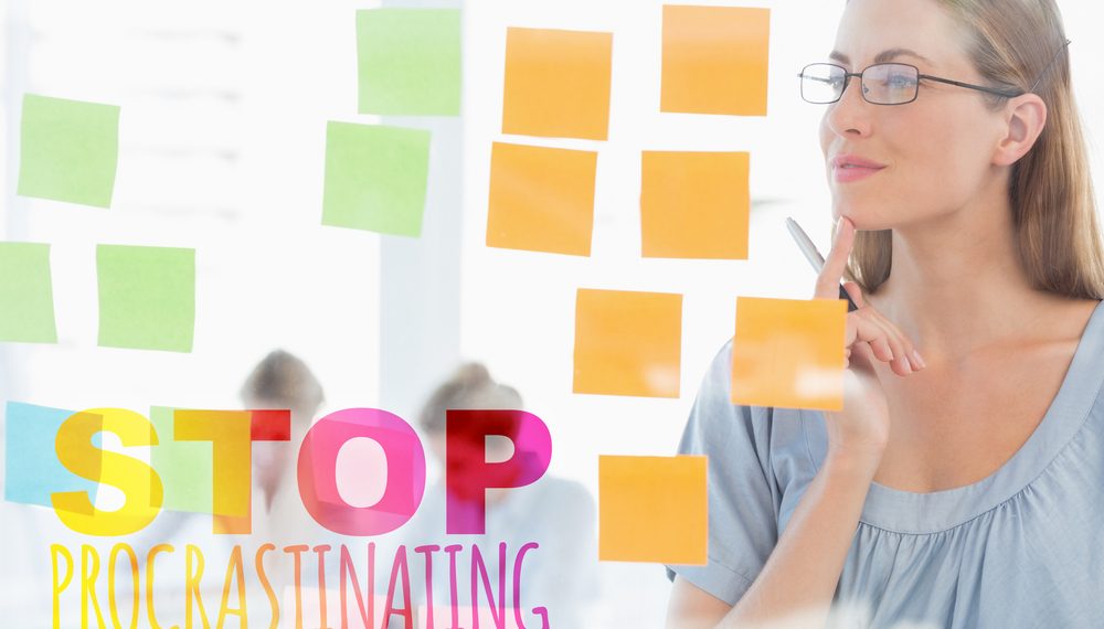 Concentrated artist looking at colorful sticky notes against stop procastinating