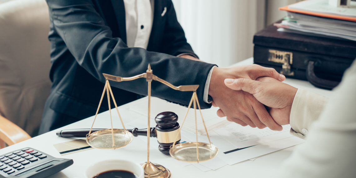 Businessman shaking hands to seal a deal with his partner lawyers or attorneys discussing a contract agreement