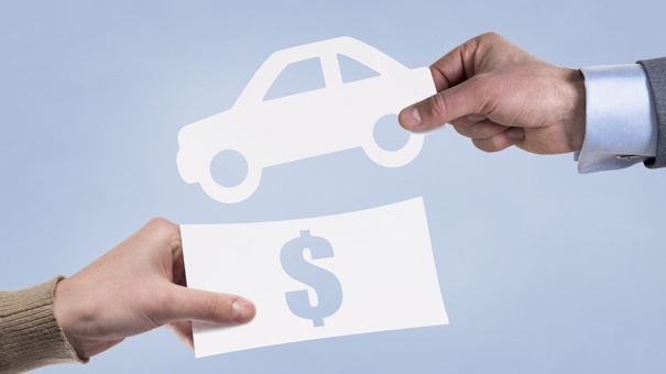 Hands taking paper icons of money and car. Leasing concept.