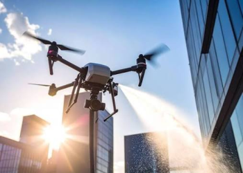 Property manager reviewing drone equipment with cleaning company representative at commercial building site