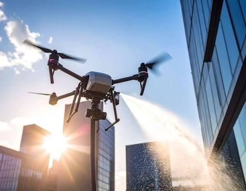 Property manager reviewing drone equipment with cleaning company representative at commercial building site