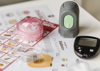 Person using laptop to order diabetic supplies online including glucose meter, test strips, and insulin supplies