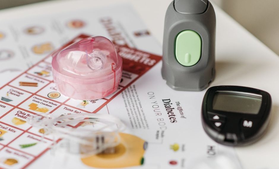 Person using laptop to order diabetic supplies online including glucose meter, test strips, and insulin supplies