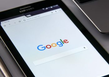 Large industrial factory overshadowed by smaller competitor appearing prominently in Google search results on laptop screen