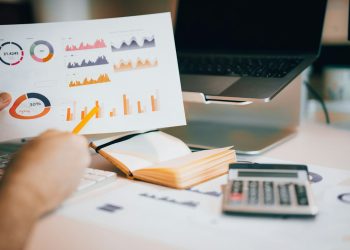 Business analyst reviewing company research and financial reports