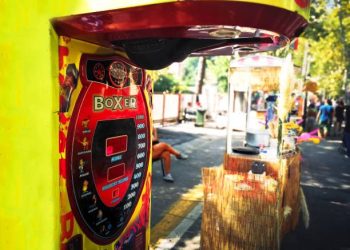 Modern arcade boxing machine and stainless steel kettle showcasing precision manufacturing and industrial design trends.