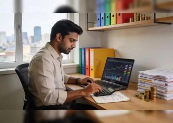 Trader calculating F&O trading costs with a calculator next to a laptop showing trading charts